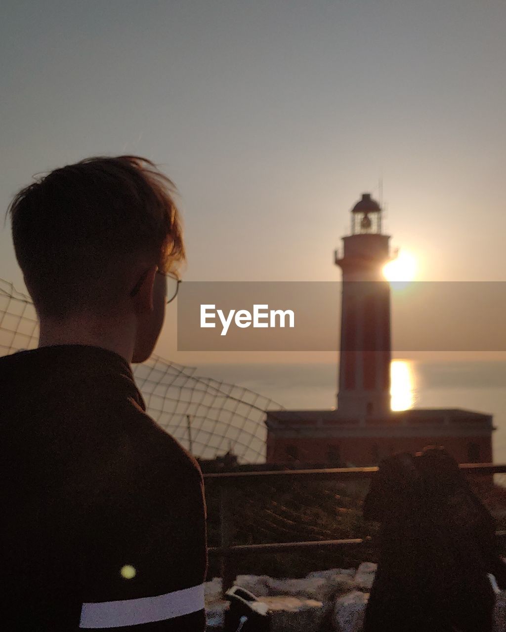 Rear view of man looking at sea against sky