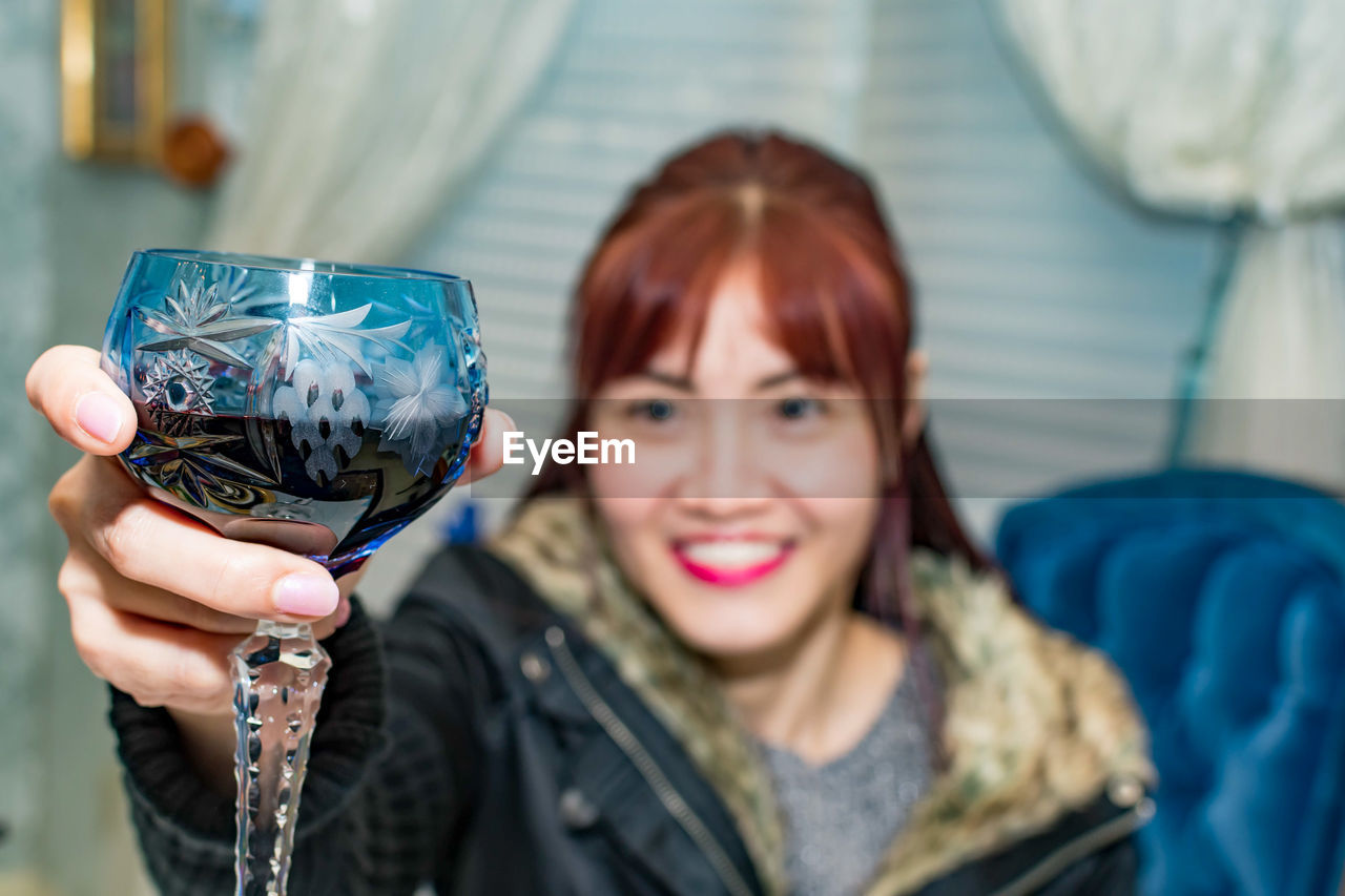 Portrait of smiling young woman holding camera