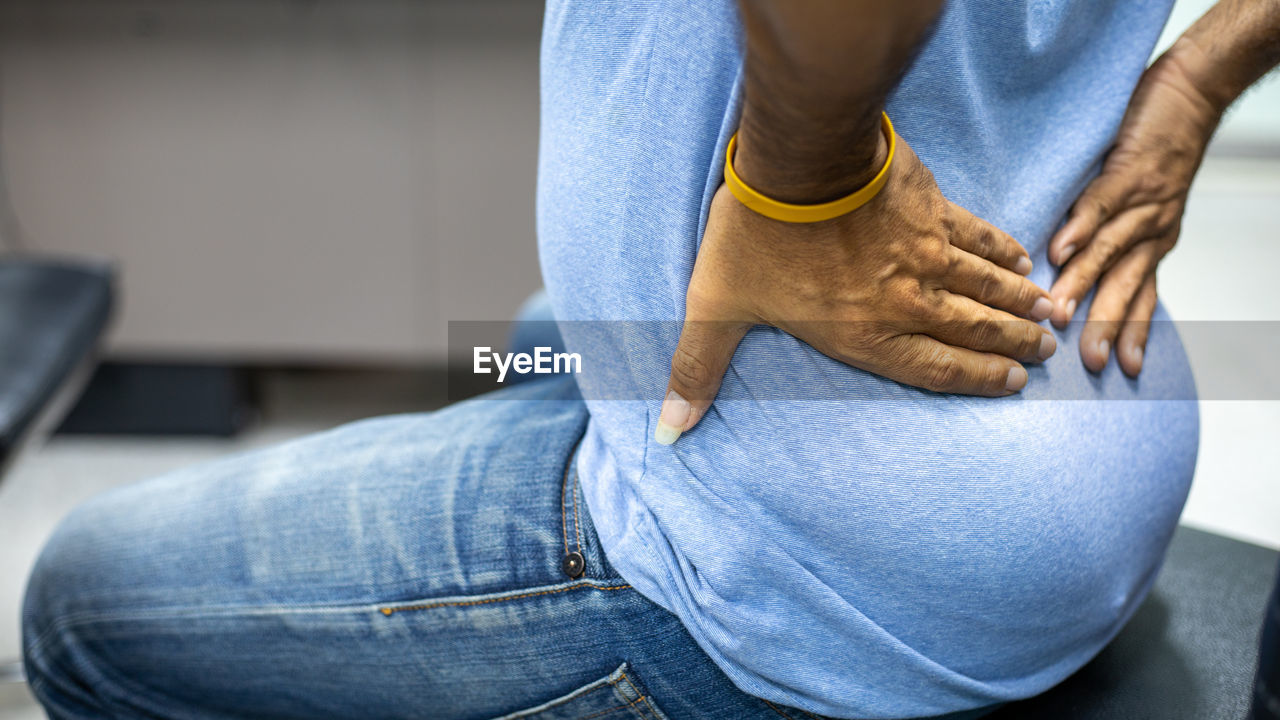 MIDSECTION OF WOMAN WITH HANDS TOUCHING HAIR