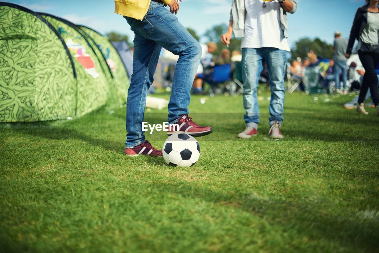 low section of people playing soccer at park