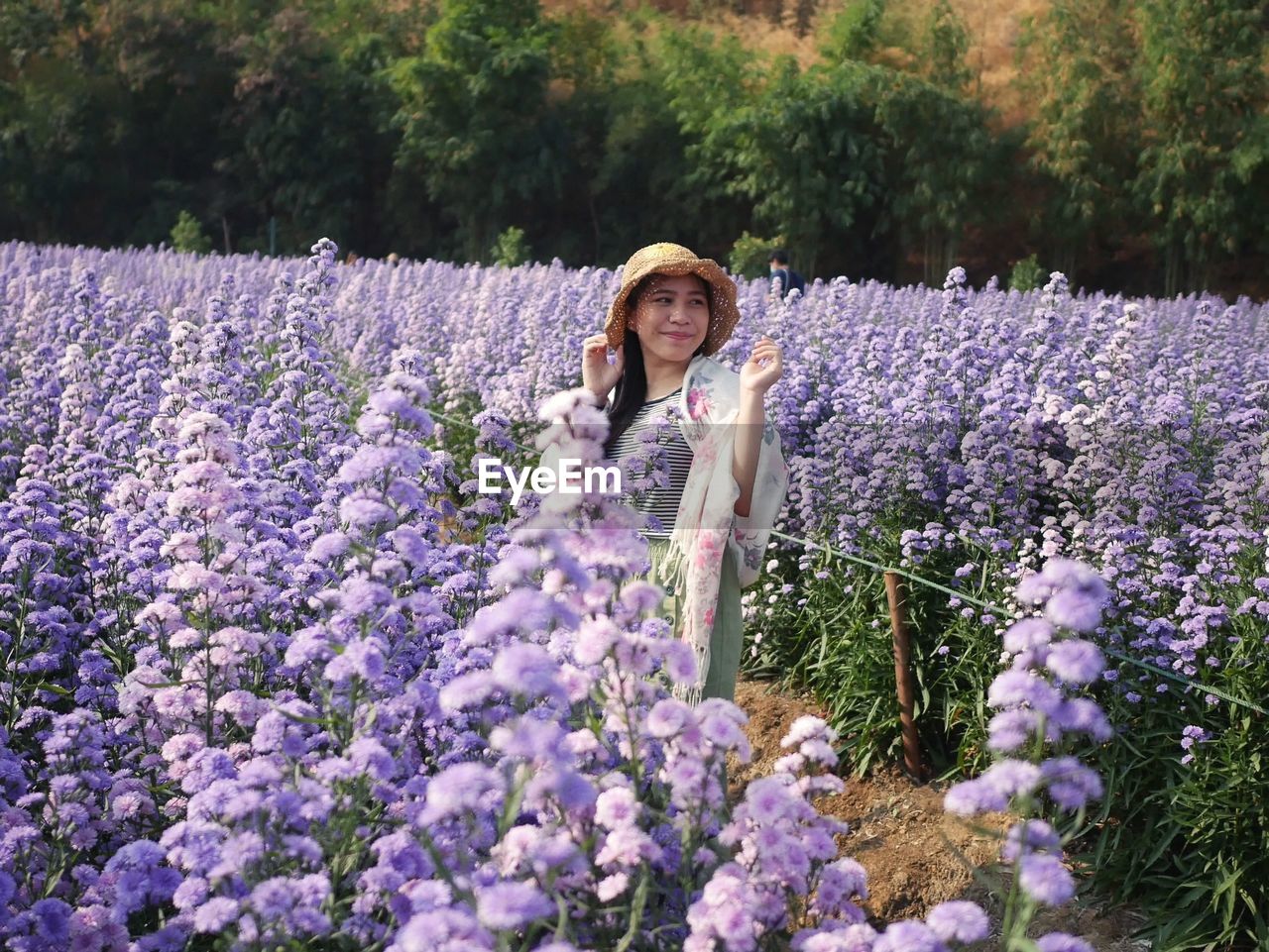 Portrait of woman with purple flowers on plants