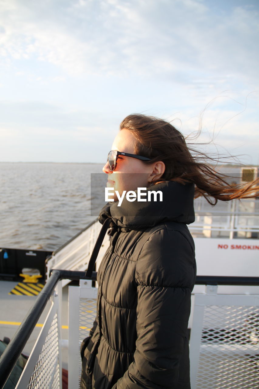 Side view of young woman travelling by boat in sea