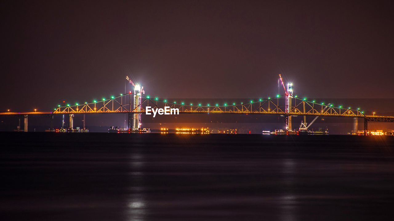 Suspension bridge over river at night