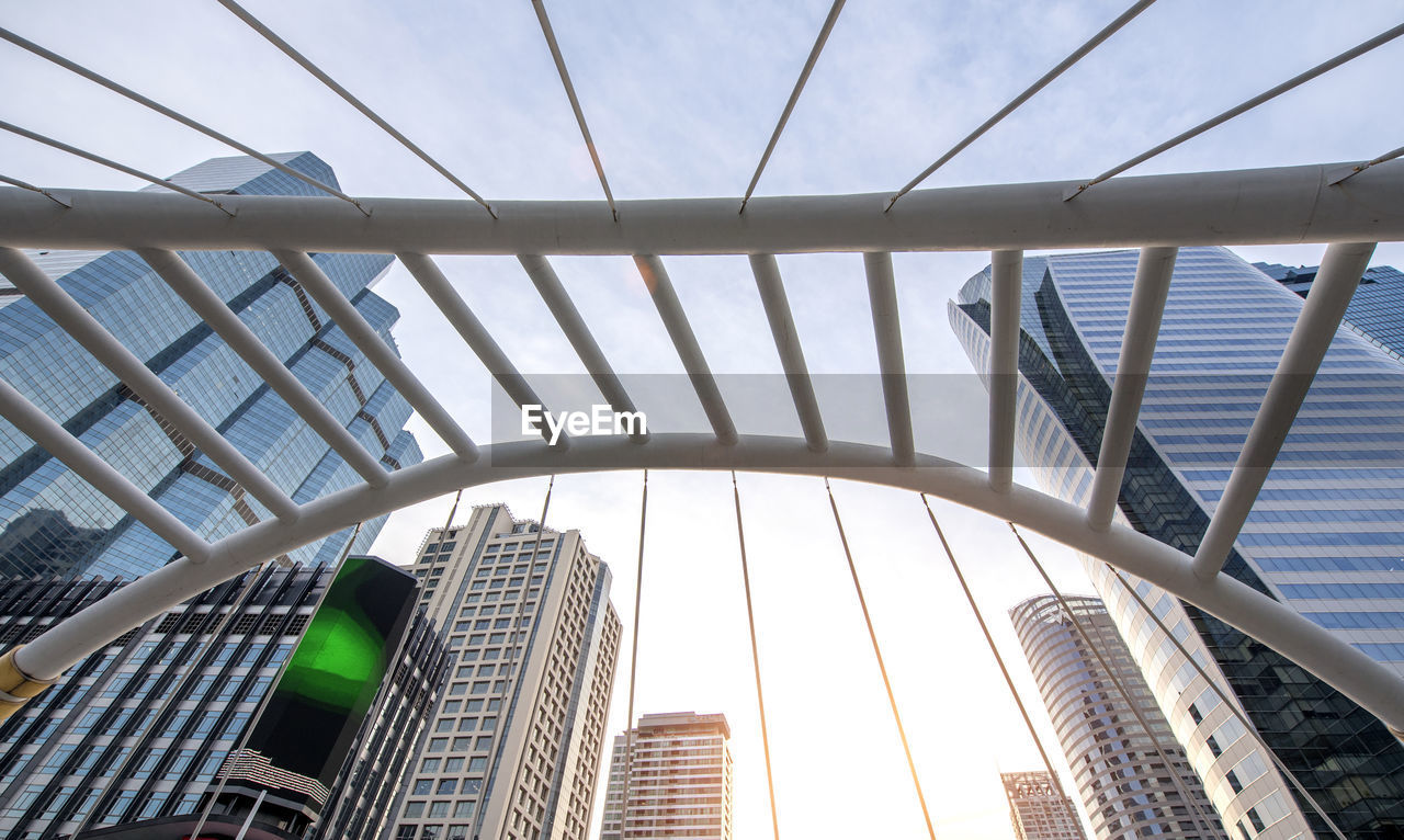 Low angle view of bridge and buildings against sky