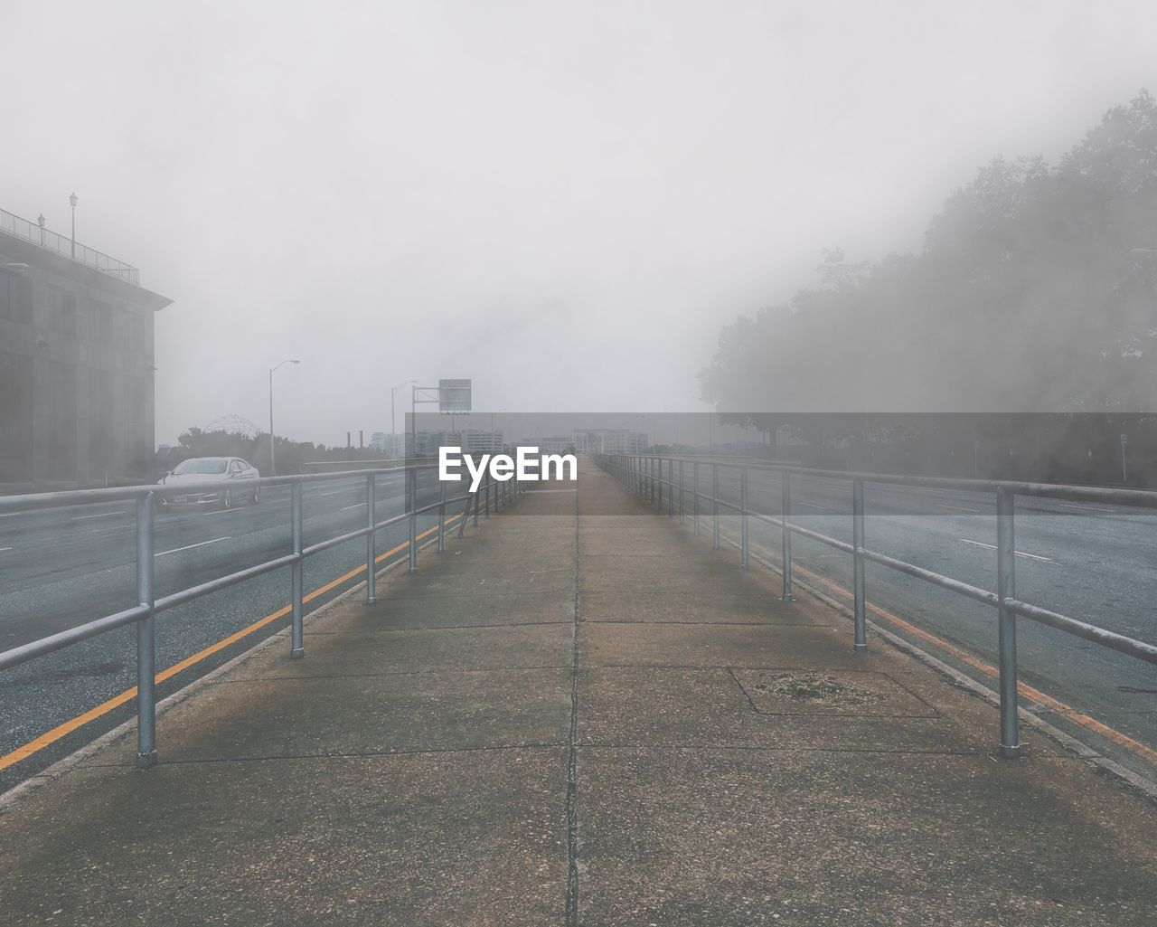 Road in city against sky during foggy weather