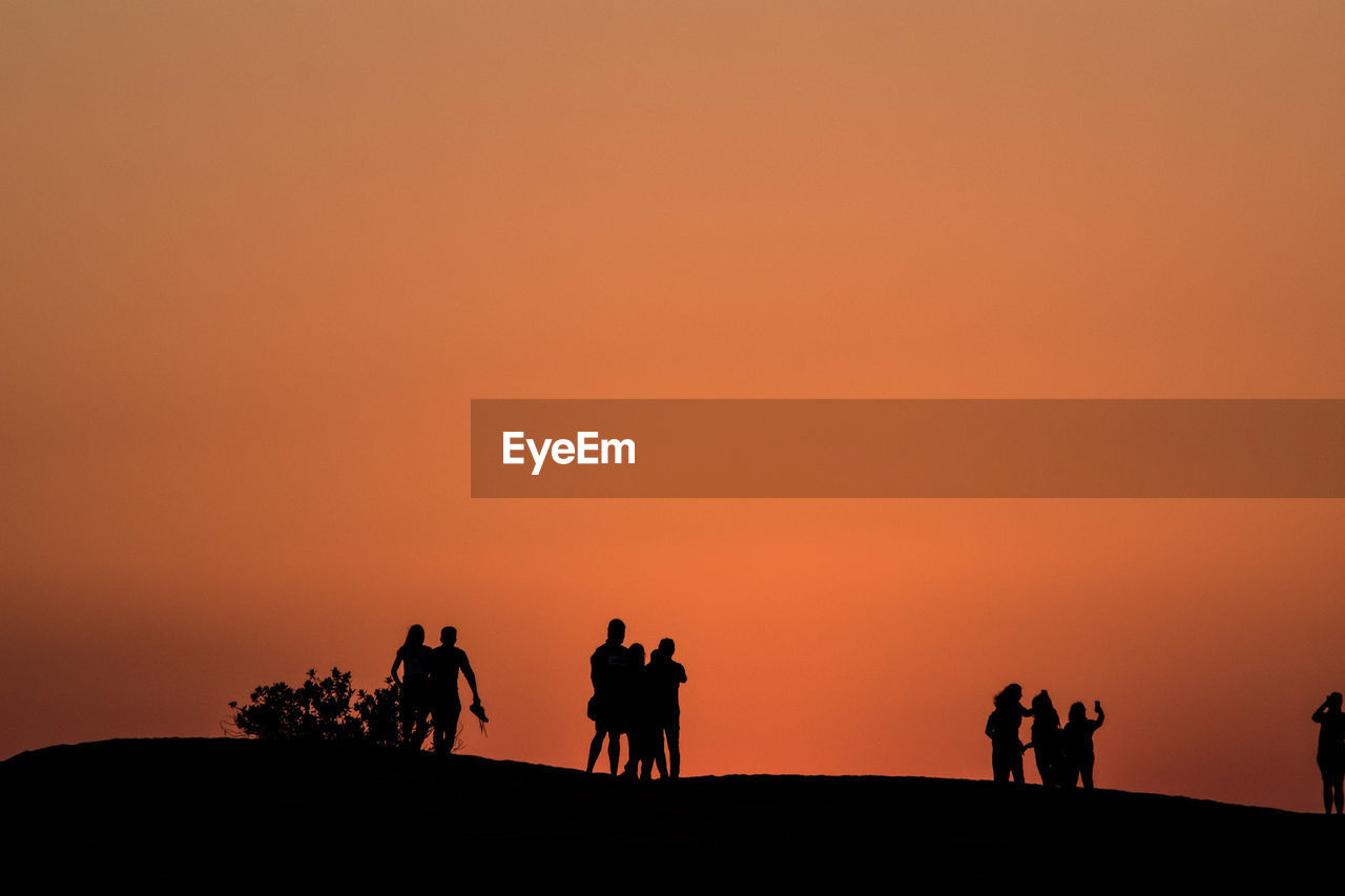 Silhouette people  against sky during sunset