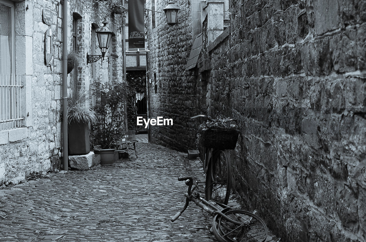 BICYCLE PARKED BY WALL