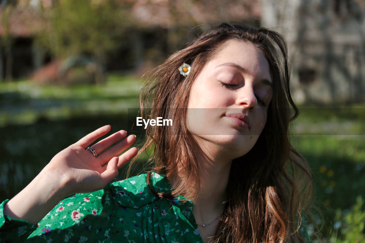 Young woman with closed eyes outdoors