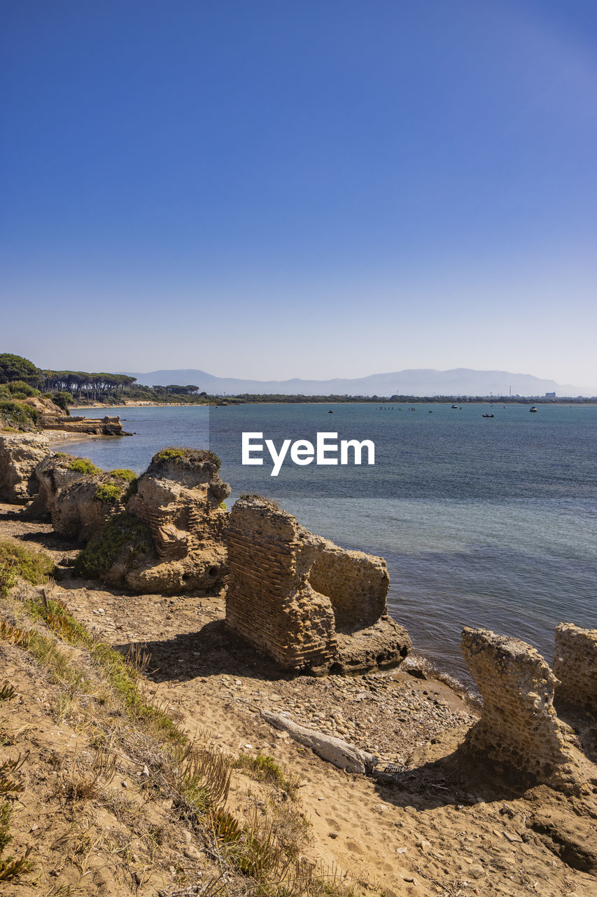 sea, water, sky, land, coast, beach, scenics - nature, shore, ocean, rock, nature, body of water, beauty in nature, horizon, clear sky, cliff, tranquility, landscape, blue, tranquil scene, travel destinations, no people, terrain, travel, coastline, bay, environment, day, sunny, outdoors, sunlight, tourism, horizon over water, cove, sand, non-urban scene, copy space, wave, seascape, idyllic, vacation