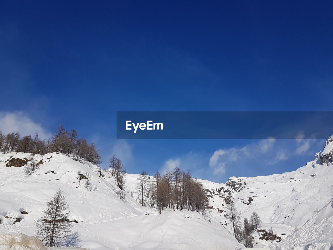 SNOW COVERED MOUNTAINS AGAINST BLUE SKY