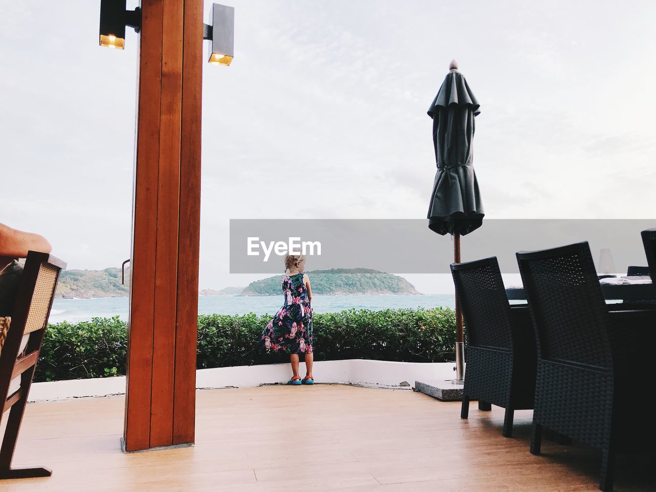 Rear view of girl standing against sky