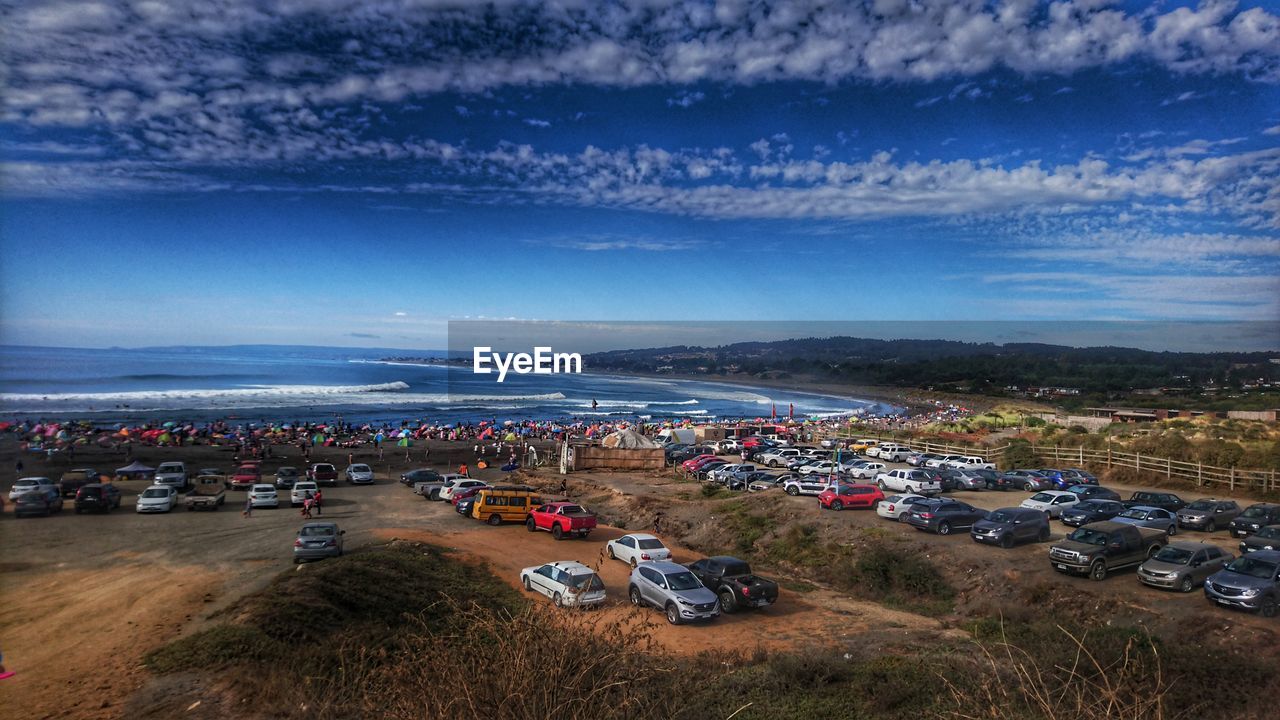 HIGH ANGLE VIEW OF CITYSCAPE AGAINST SEA