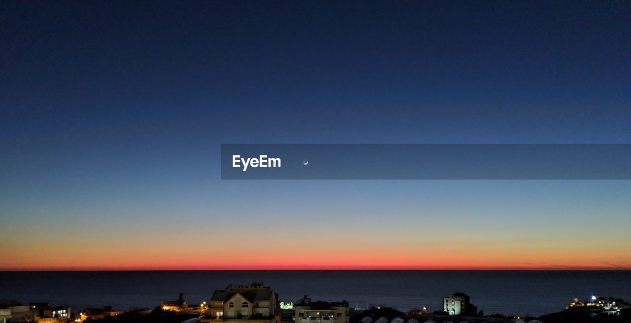 SCENIC VIEW OF SEA AGAINST CLEAR SKY AT NIGHT