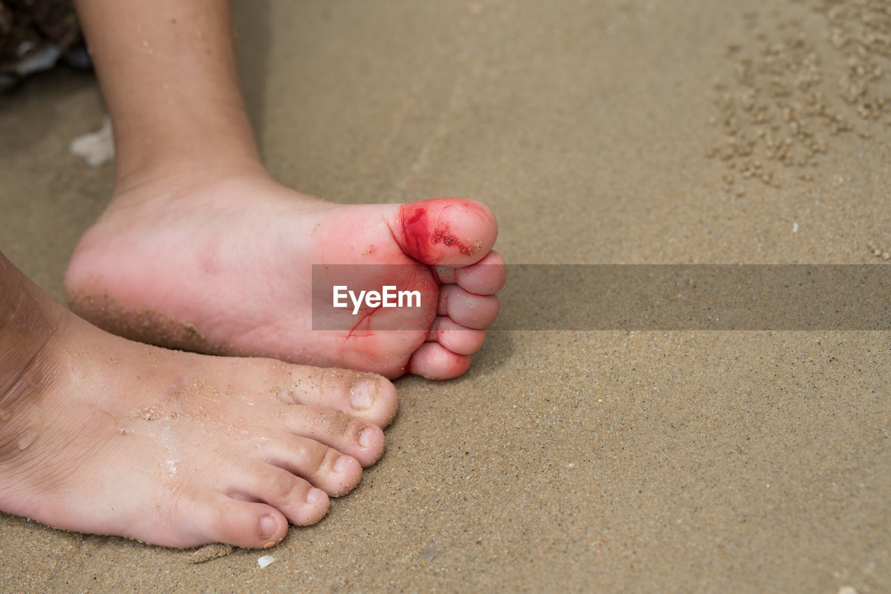 LOW SECTION OF CHILD ON SAND