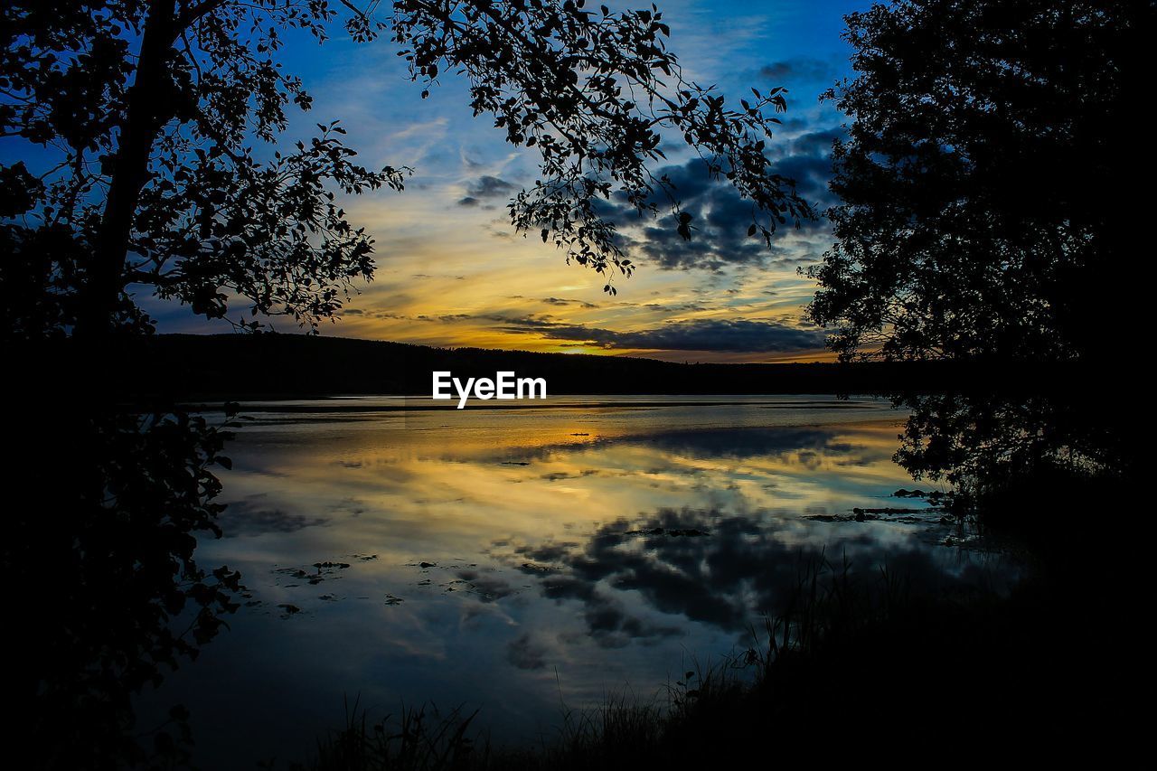 SCENIC SHOT OF CALM LAKE AGAINST SKY