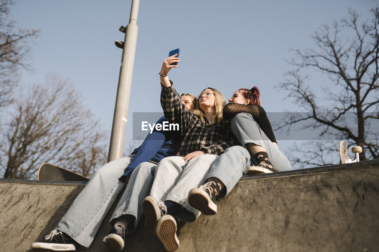 Teenage girls taking selfie in skatepark