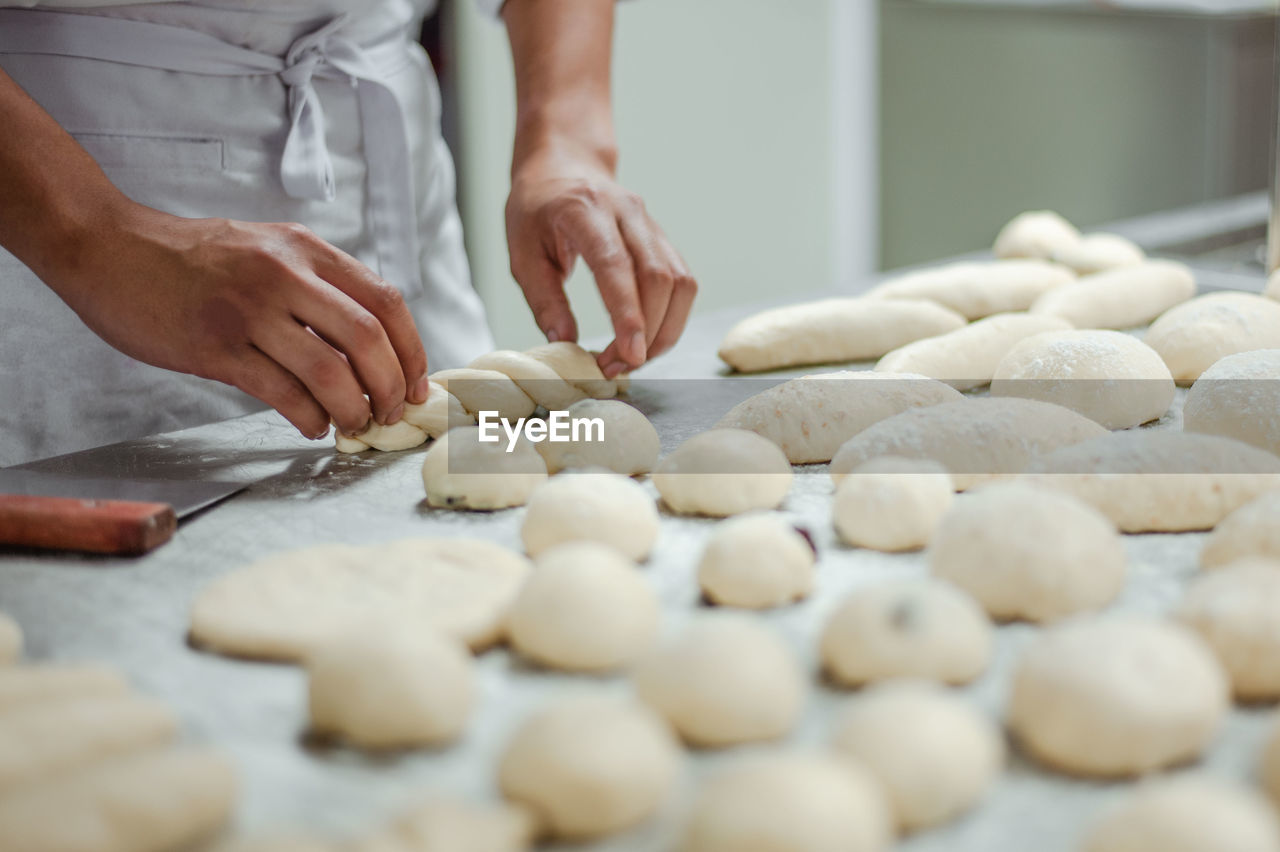 Midsection of chef preparing dough in kitchen