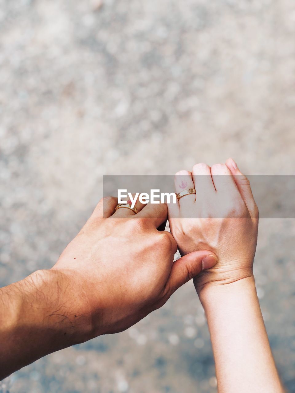 Cropped hands of couple wearing rings