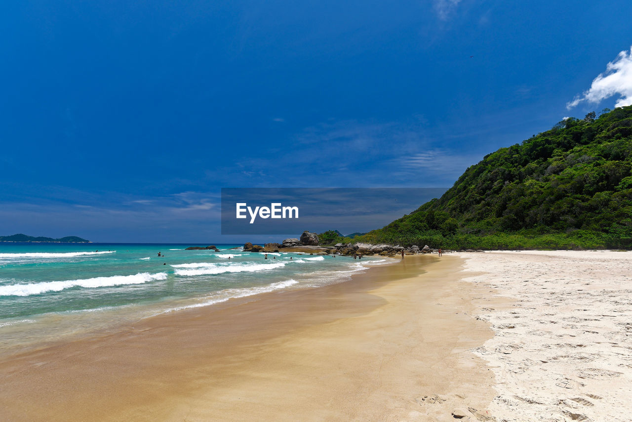 Scenic view of beach against blue sky