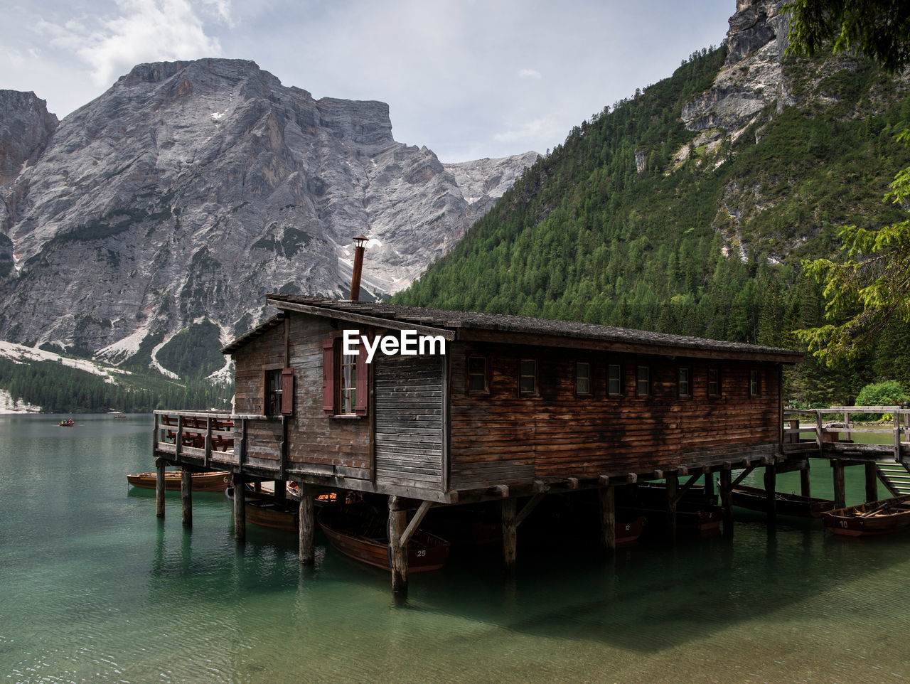 VIEW OF COTTAGE BY LAKE AND MOUNTAINS