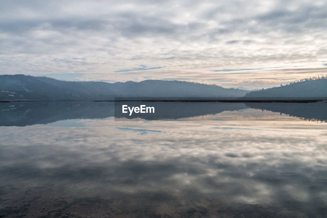 SCENIC VIEW OF LAKE BY MOUNTAIN AGAINST SKY