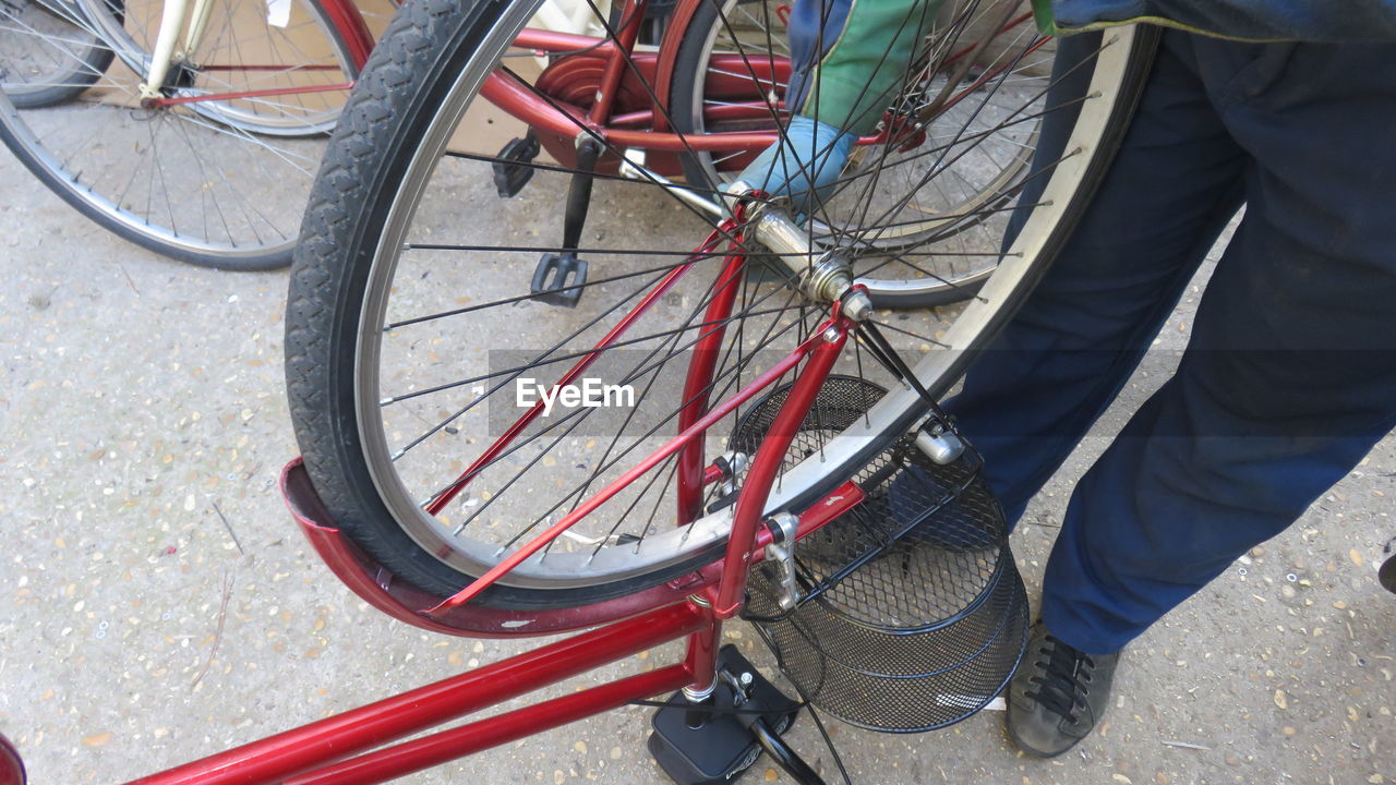 Low section of man repairing punctured bicycle
