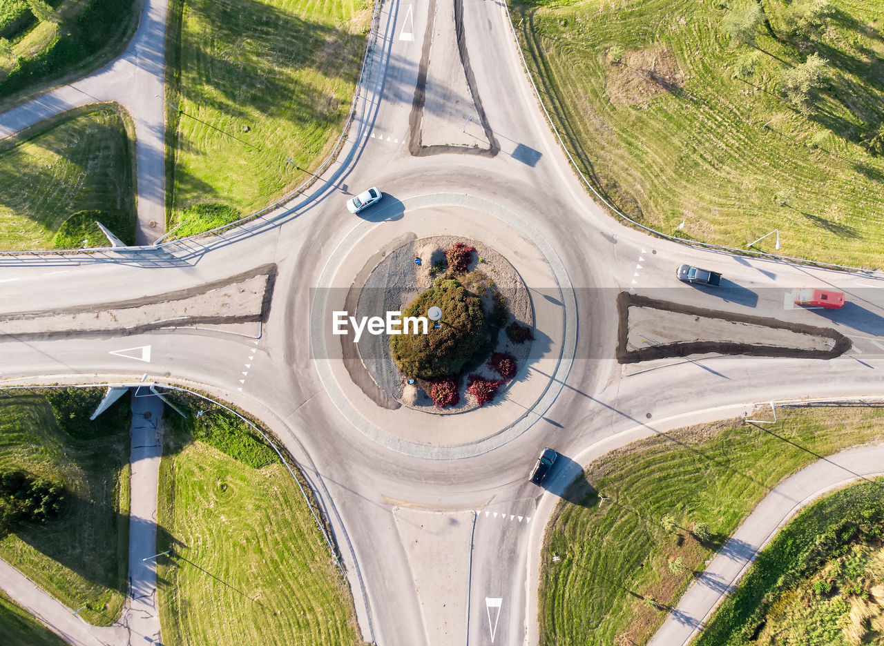 A roundabout from a drone point of view. there are a couple of cars driving in and out. 