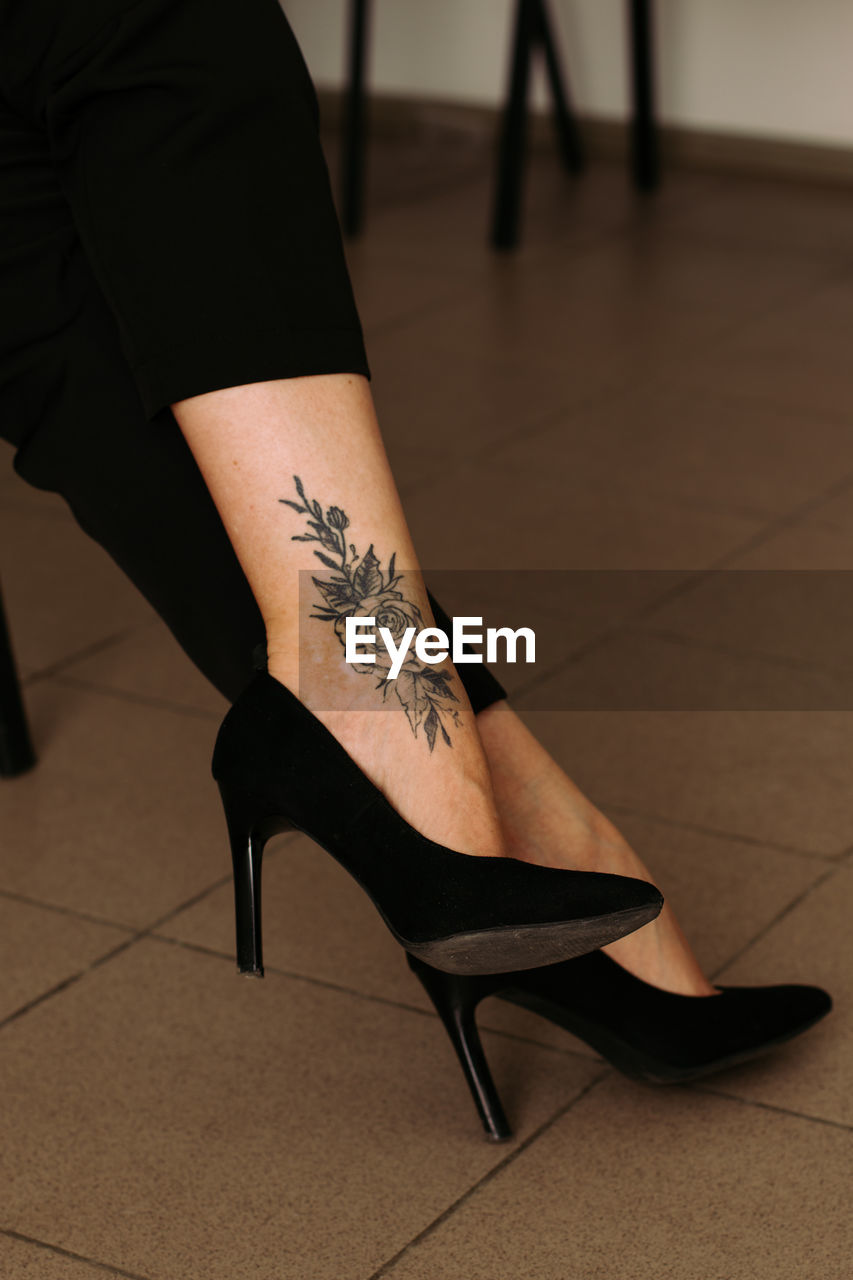 Tattoo, woman legs in shoes