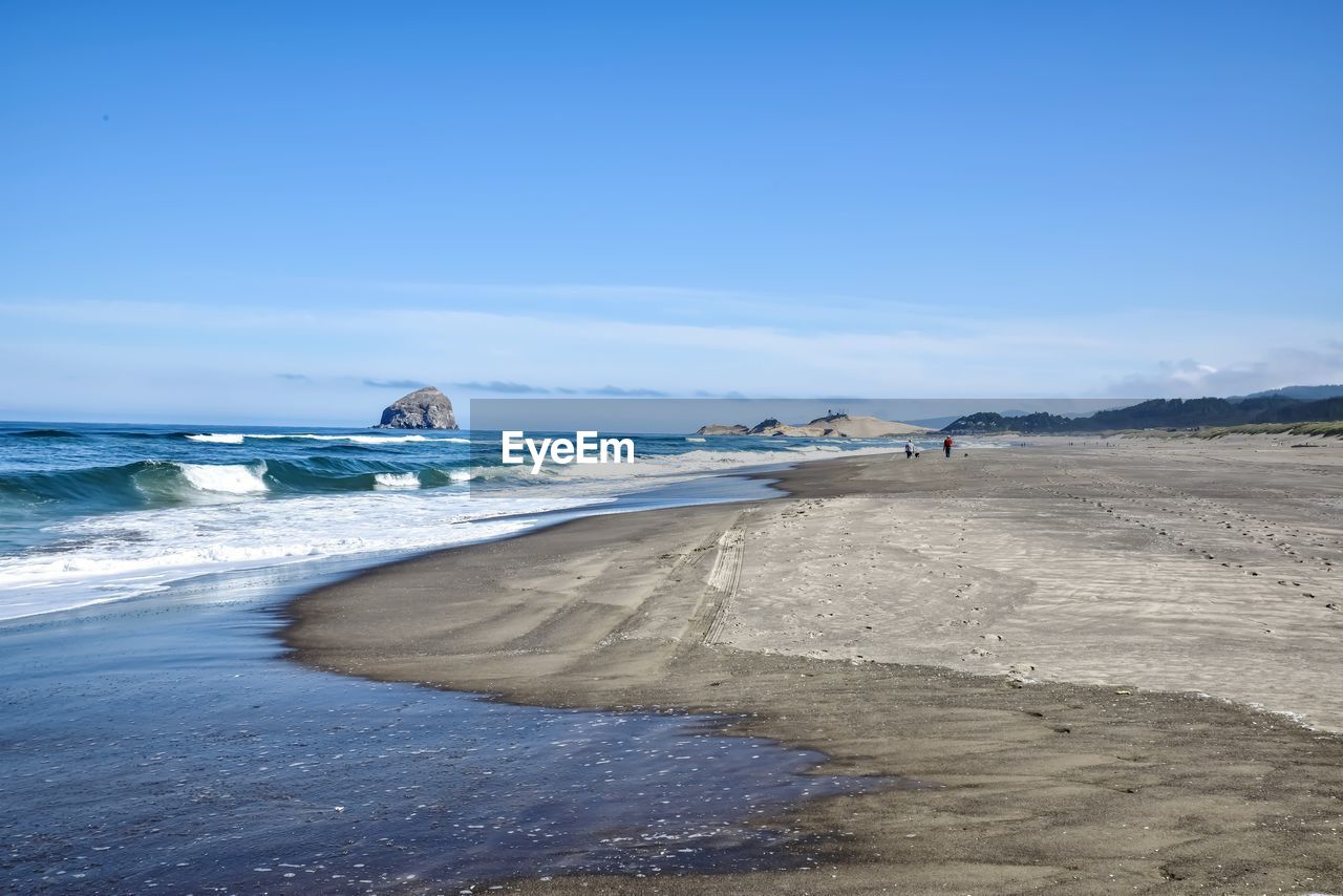Scenic view of beach against blue sky