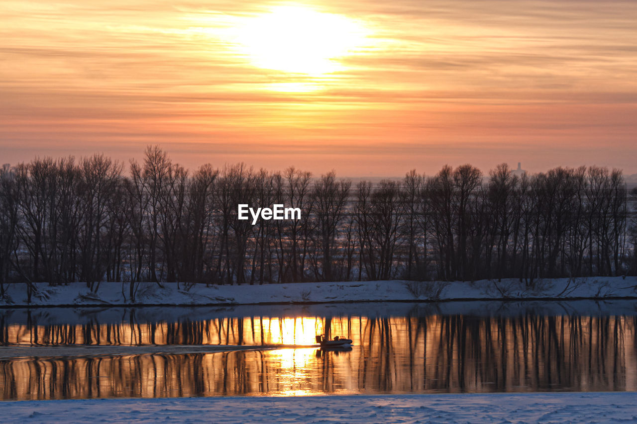 Scenic view of lake against orange sky