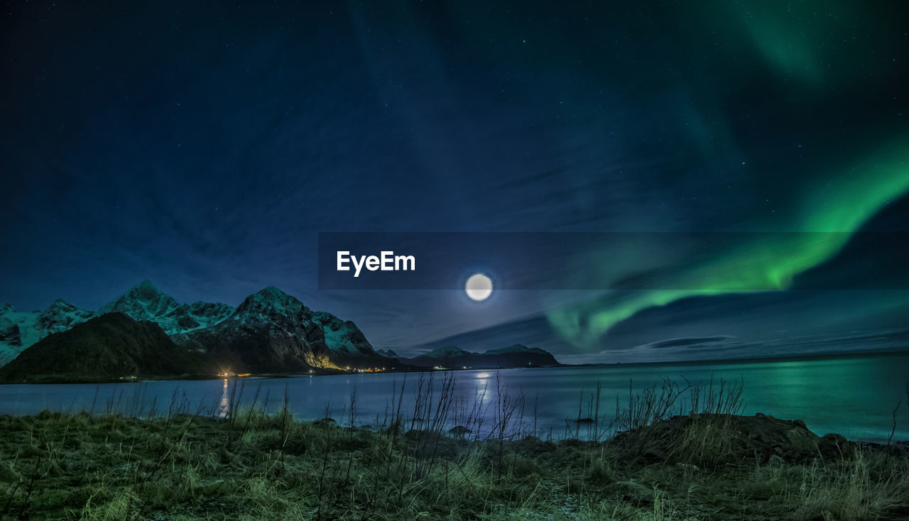 Scenic view of lake against sky at night