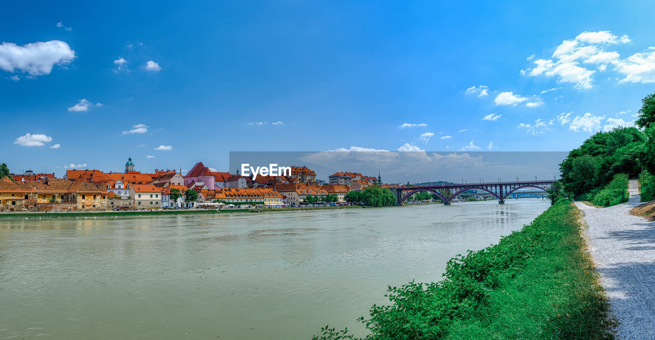 RIVER BY BUILDINGS AGAINST SKY