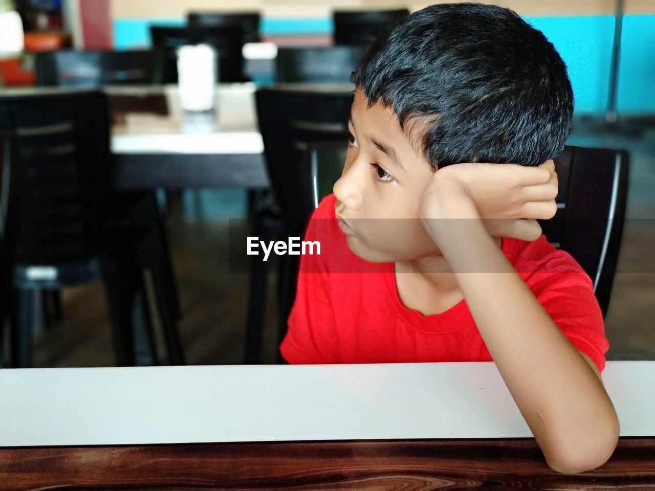 Close-up of thoughtful boy looking away while sitting at table