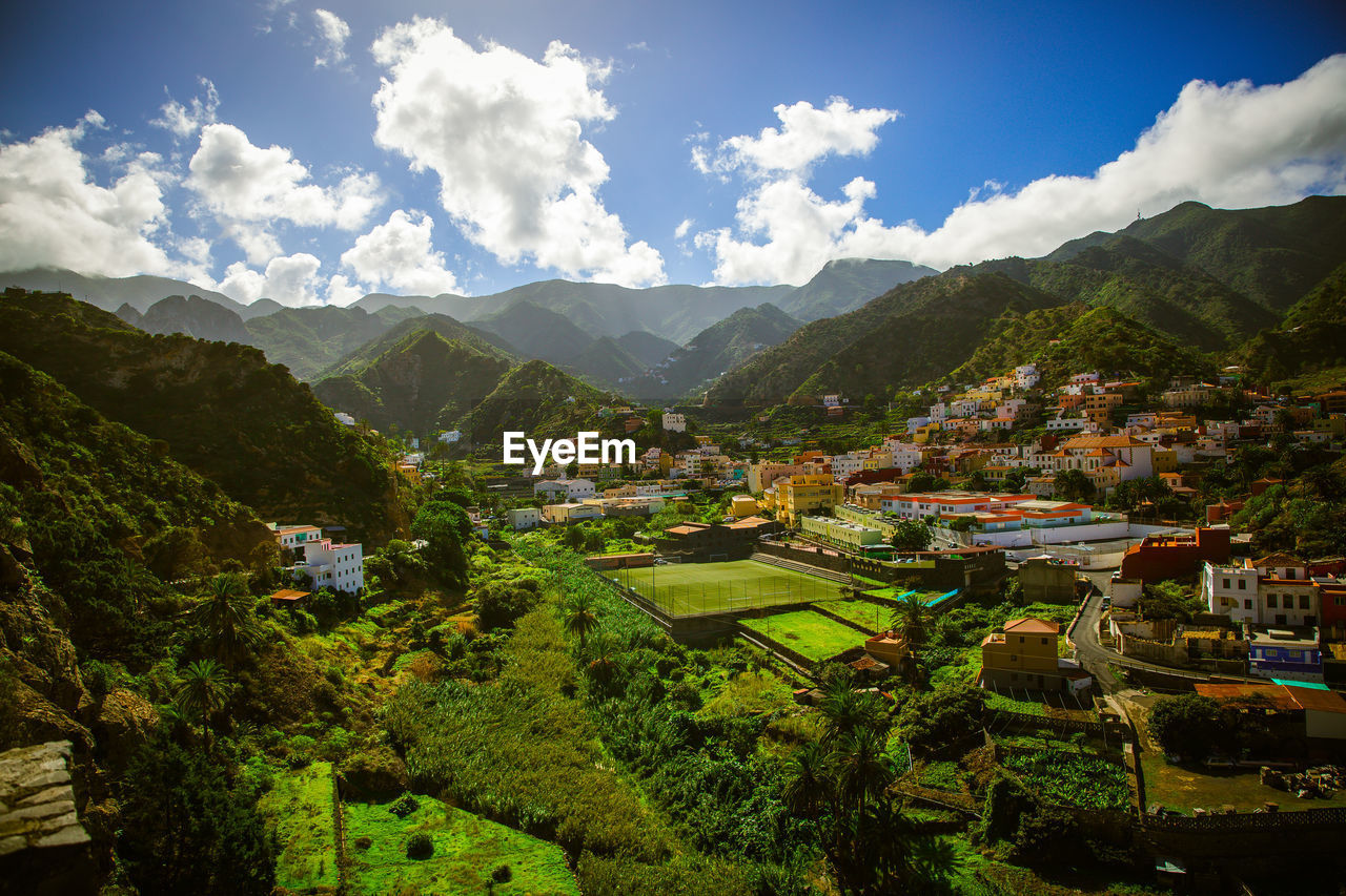 Scenic view of townscape and mountains against sky