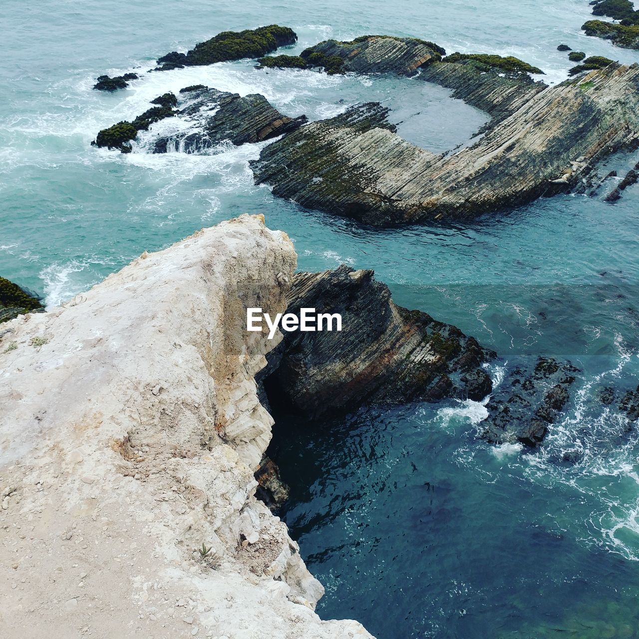 High angle view of rocks in sea against sky