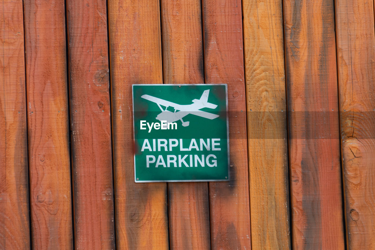 Close-up of warning sign on wooden plank