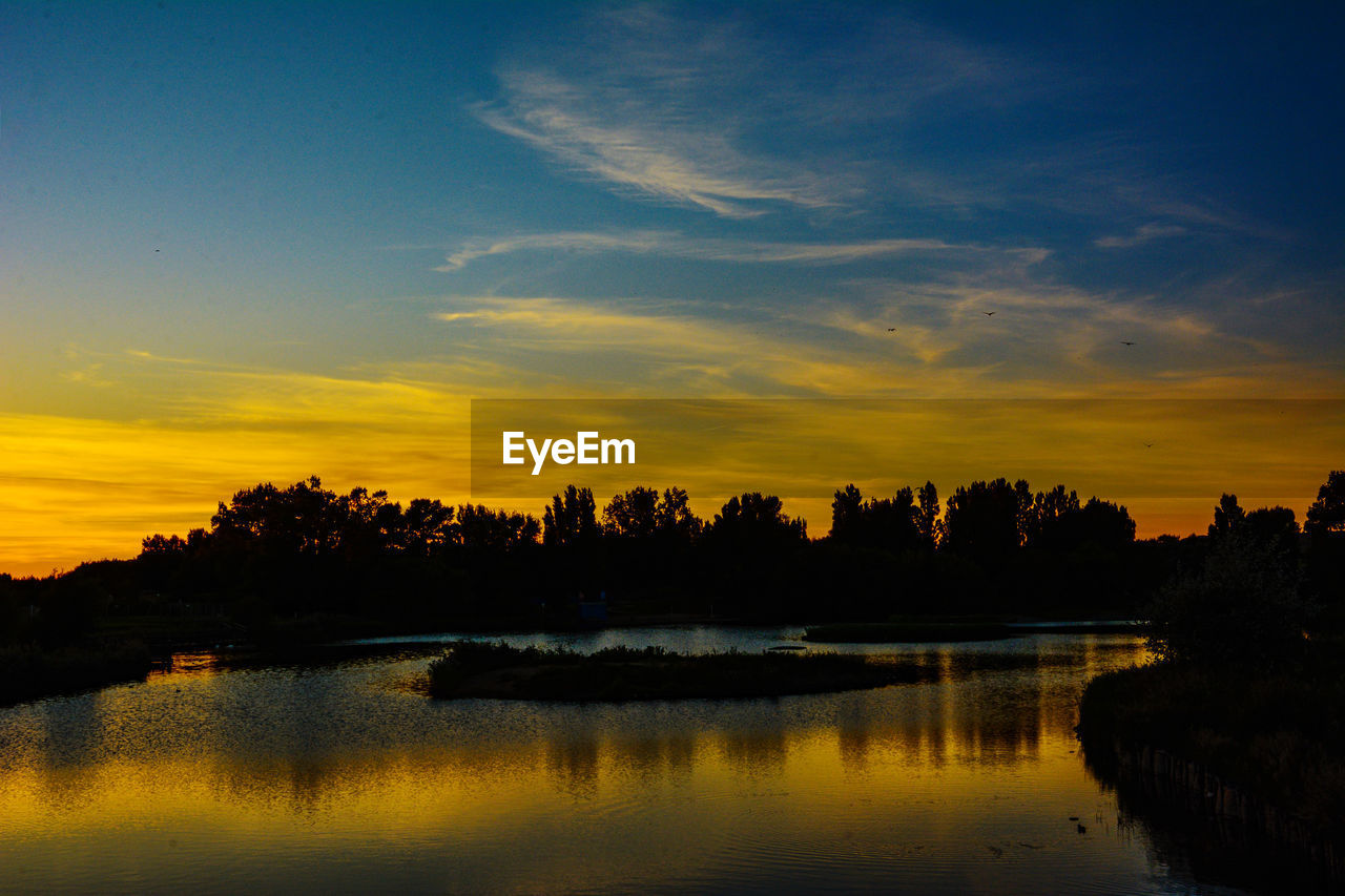 SCENIC VIEW OF LAKE AGAINST ORANGE SKY