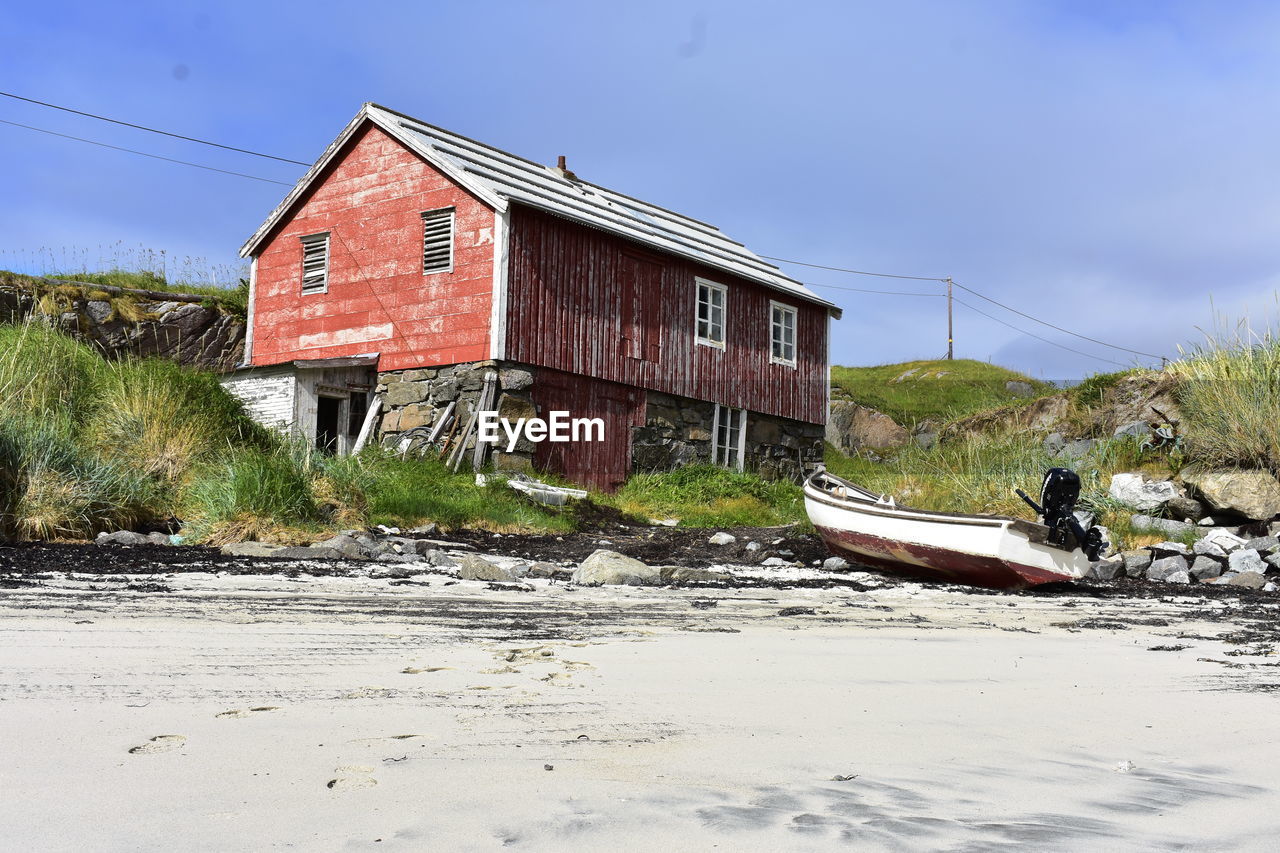 Abandoned building by beach against sky