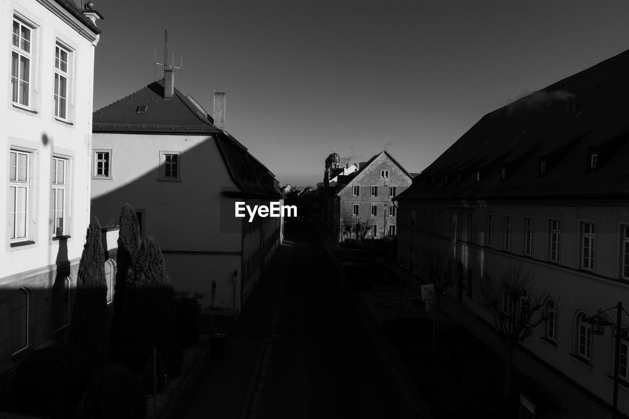 HOUSES AMIDST BUILDINGS IN TOWN AGAINST SKY