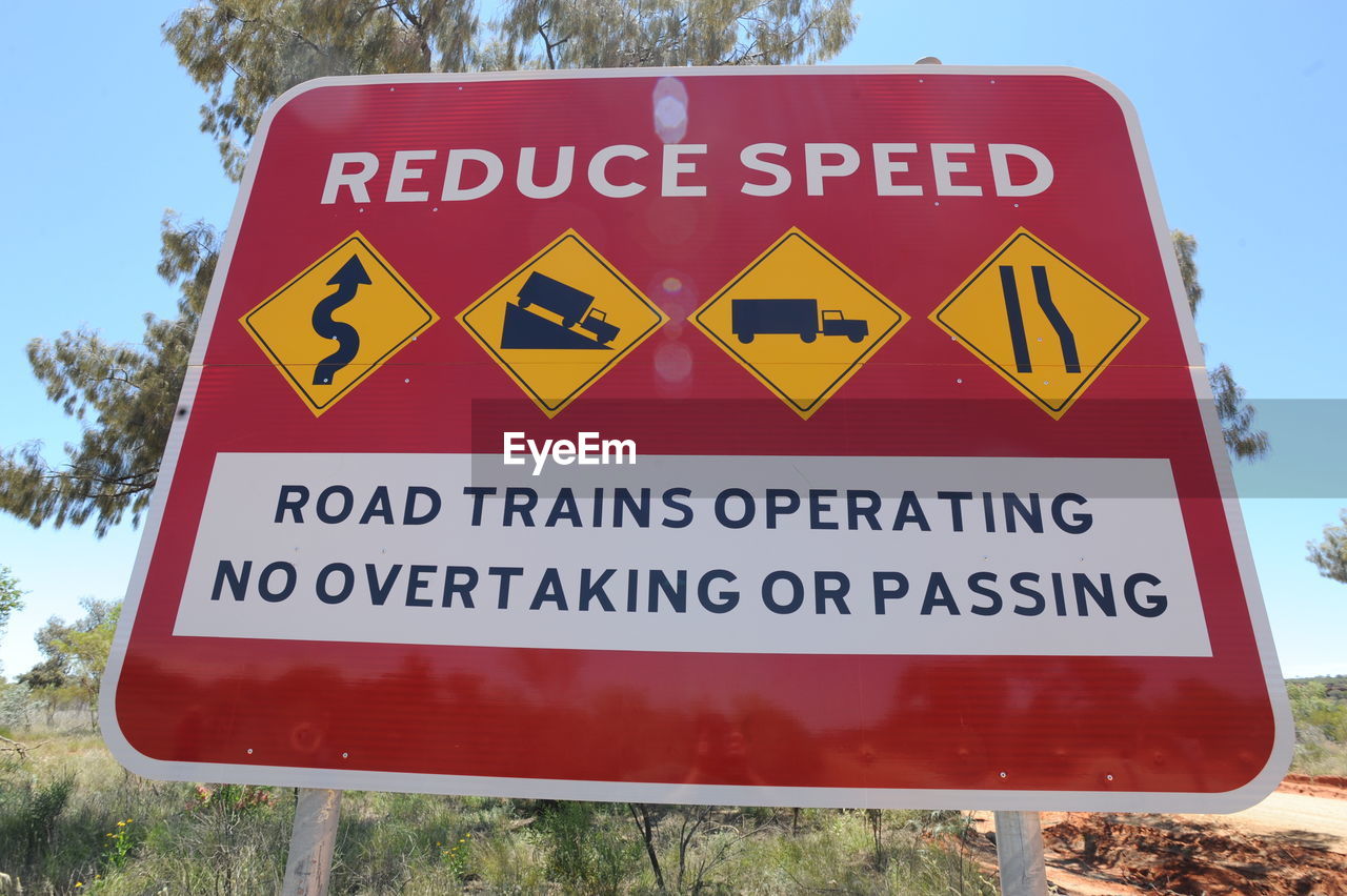 CLOSE-UP OF ROAD SIGN AGAINST THE SKY