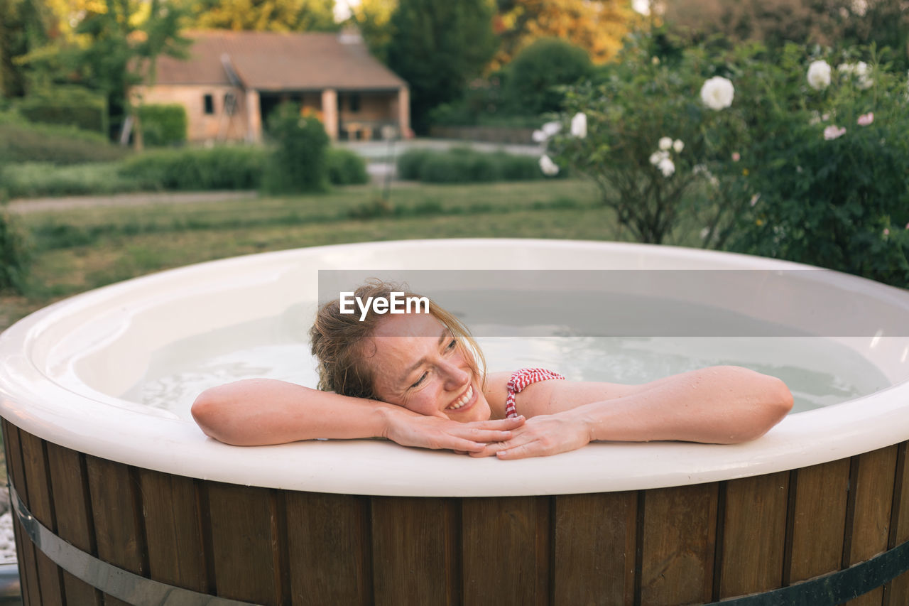 Beautiful woman relaxing taking hot bath in countryside resort