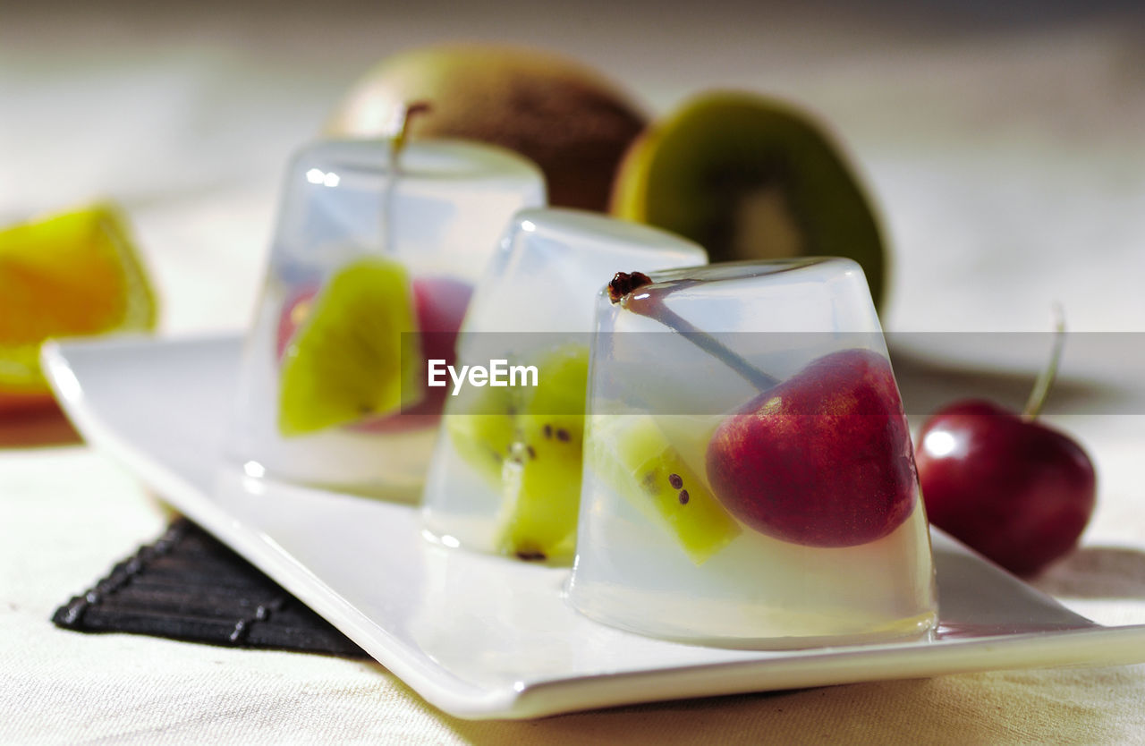 CLOSE-UP OF FRUITS IN PLATE ON TABLE WITH SPOON