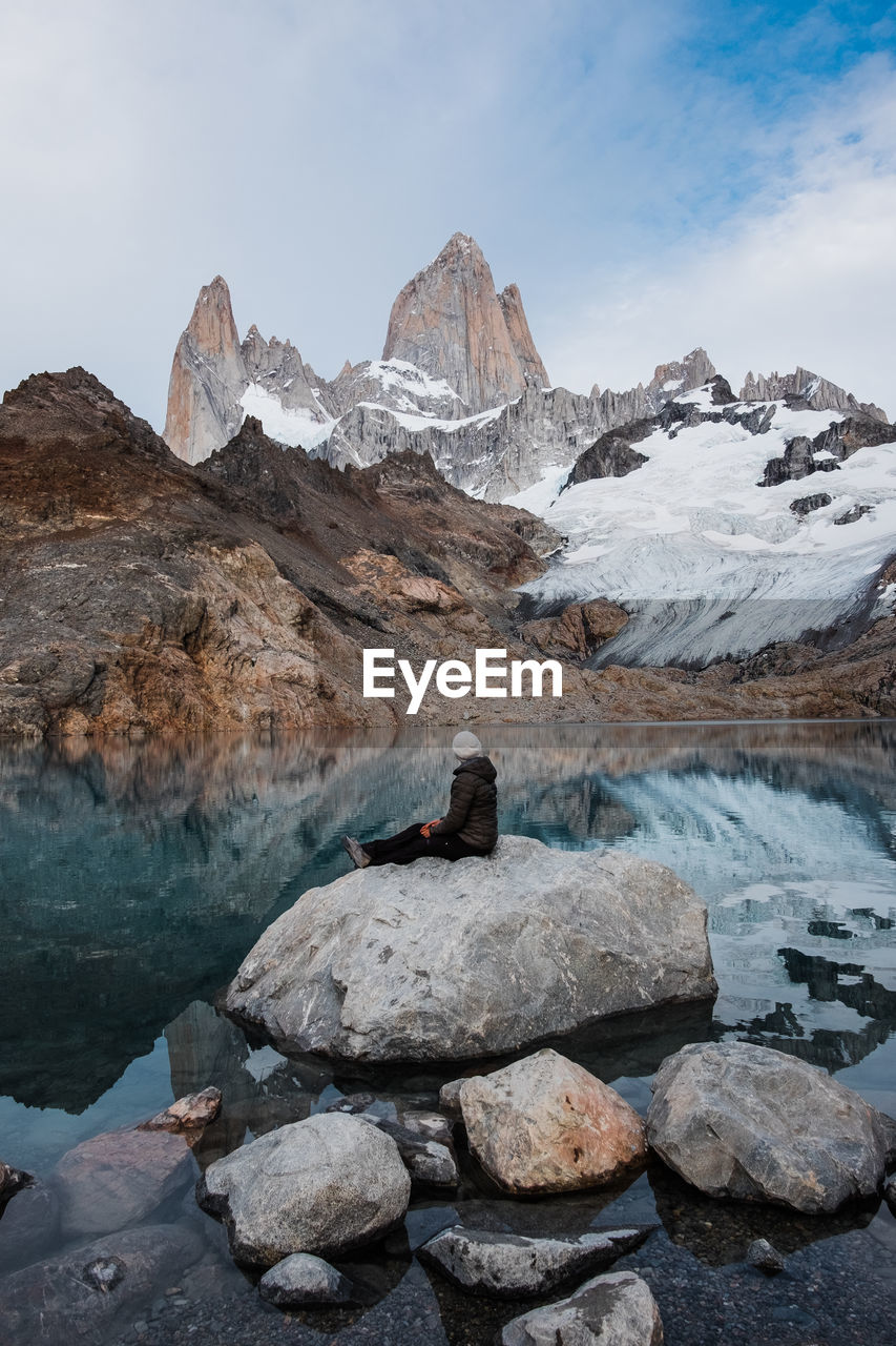 Woman sitting on a stone looking towards fitz roy