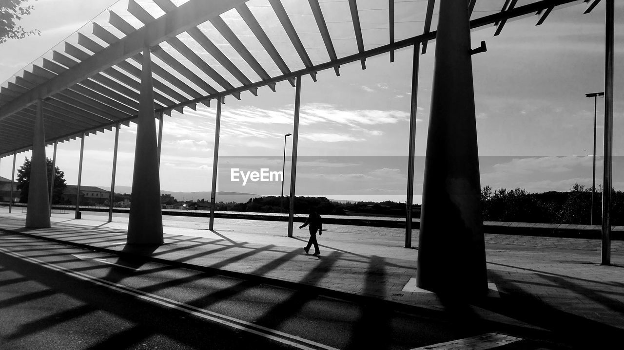 SILHOUETTE MAN WALKING IN CITY AGAINST SKY SEEN FROM WINDSHIELD