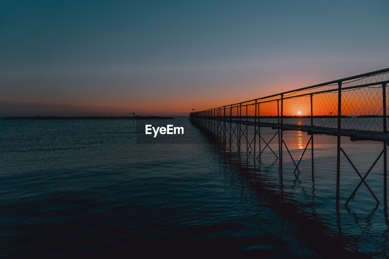 SCENIC VIEW OF SEA AGAINST ORANGE SKY