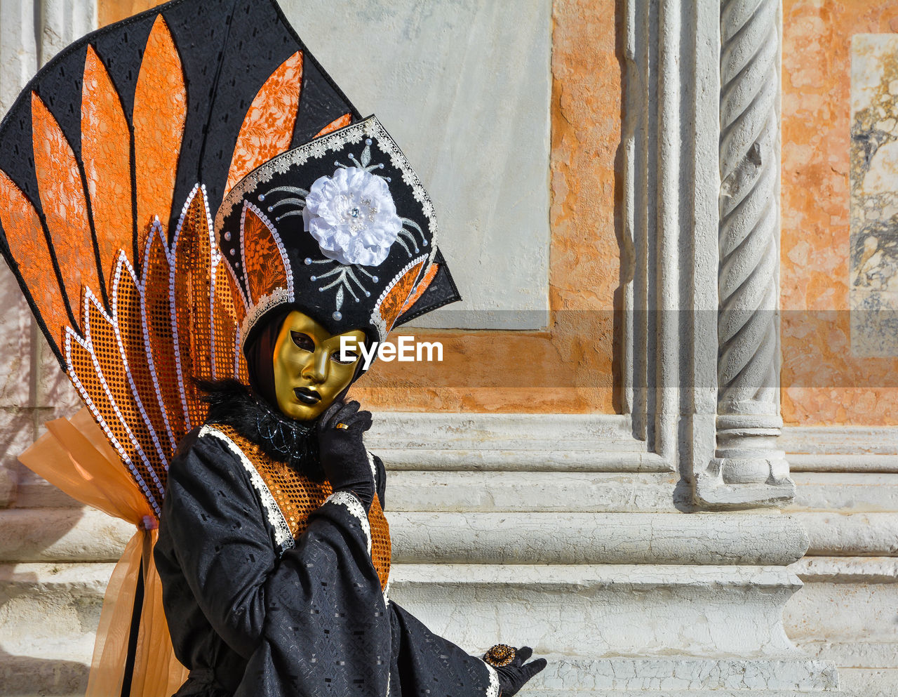 Portrait of person dressed up for carnival against wall