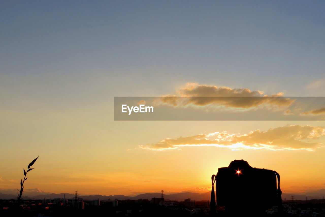 Silhouette city against sky during sunset