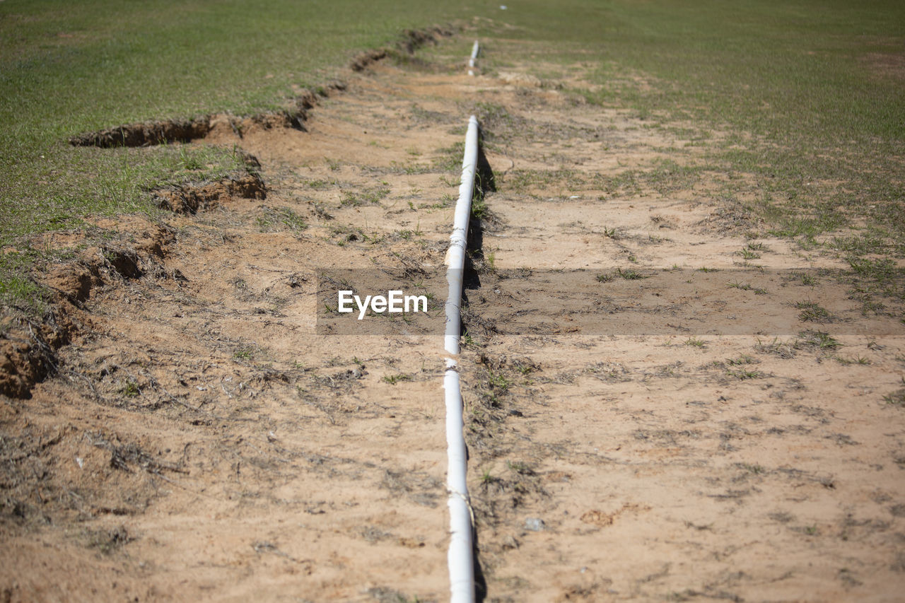 Long pvc pipe leading through a ditch into the distance