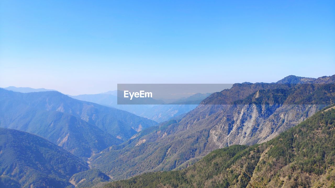 Scenic view of mountains against clear blue sky