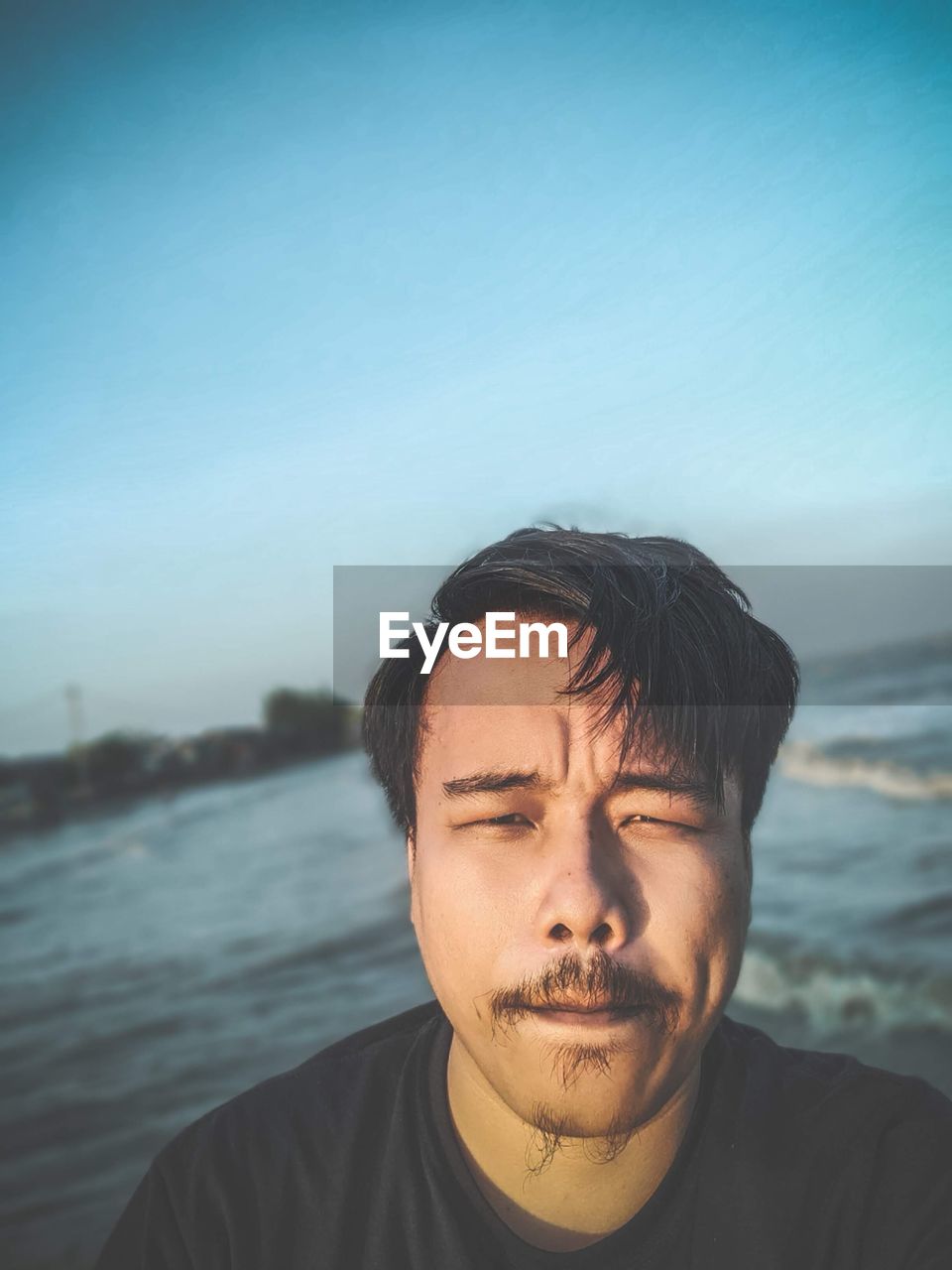 Portrait of young man against sea